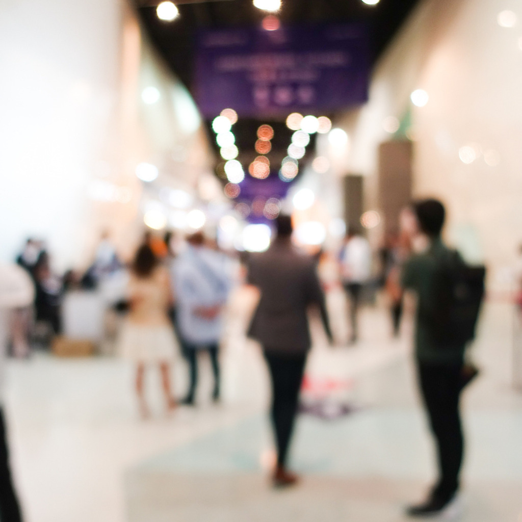 Blurred, defocused background of public exhibition hall. Business tradeshow or stock market, organization or company event, commercial trading fair, or shopping mall marketing advertisement concept